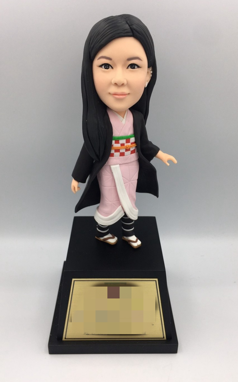 Front view of a hand-shaped clay portrait doll